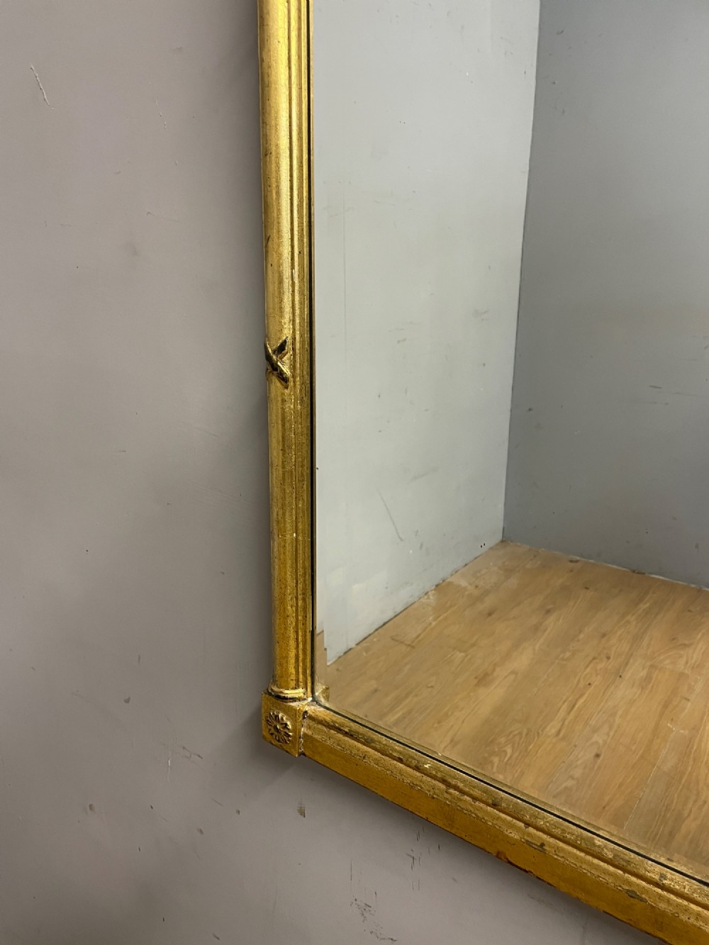 A rectangular giltwood wall mirror featuring a projecting cornice top, classical column pilasters, arcaded frieze details, and rosette corner blocks. View VII