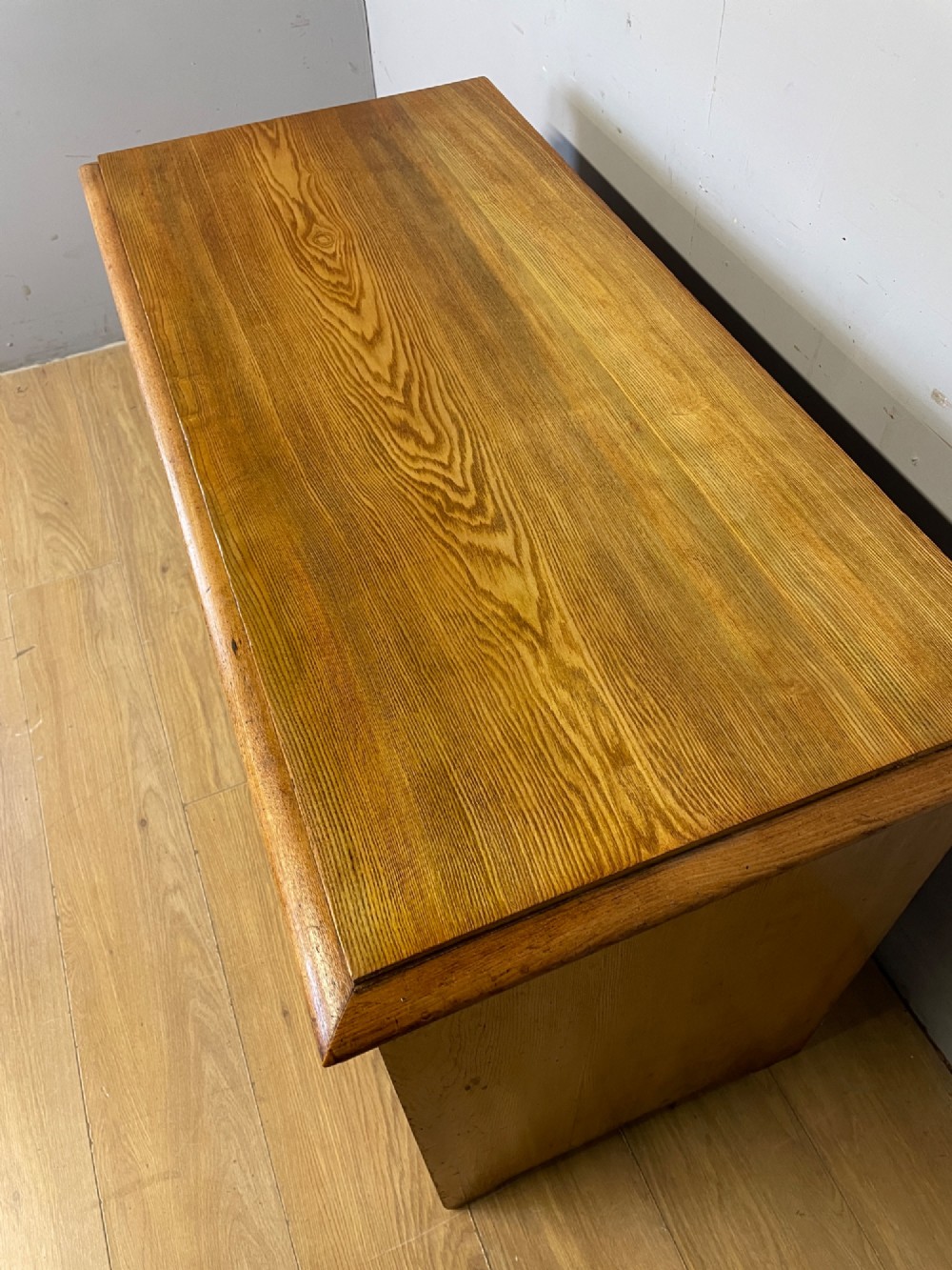 An Arts and Crafts solid ash chest of drawers featuring two short drawers over two long drawers with brass drop handles and dark linear inlay. View III