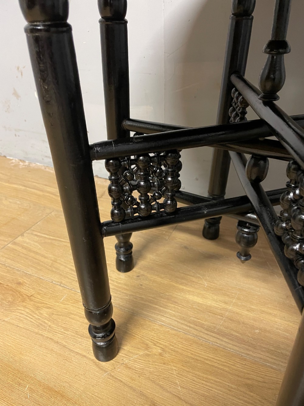 An Anglo-Indian circular brass tray table with hand-engraved patterns supported on an ebonised wooden base with turned legs. View IV