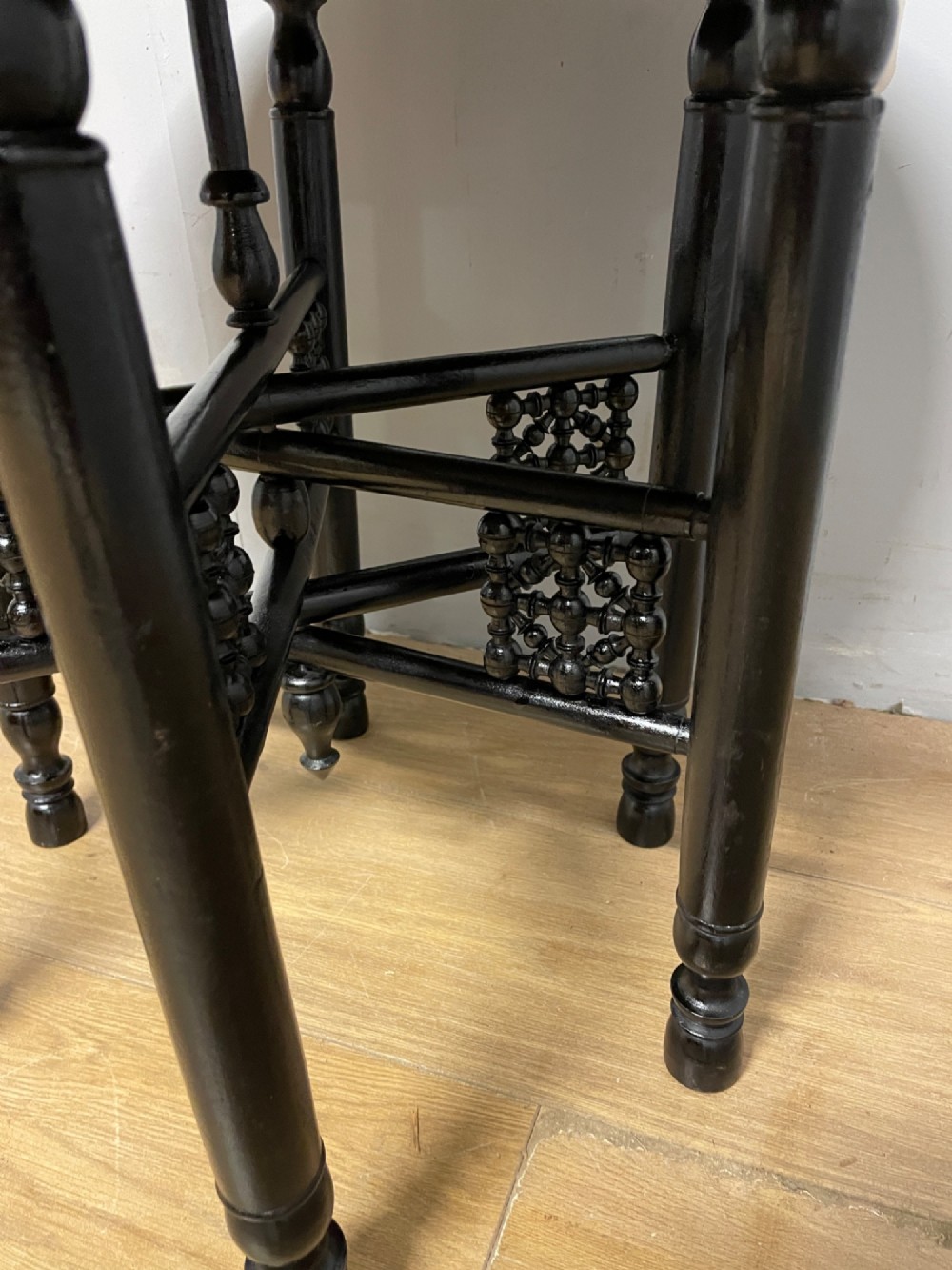 An Anglo-Indian circular brass tray table with hand-engraved patterns supported on an ebonised wooden base with turned legs. View V