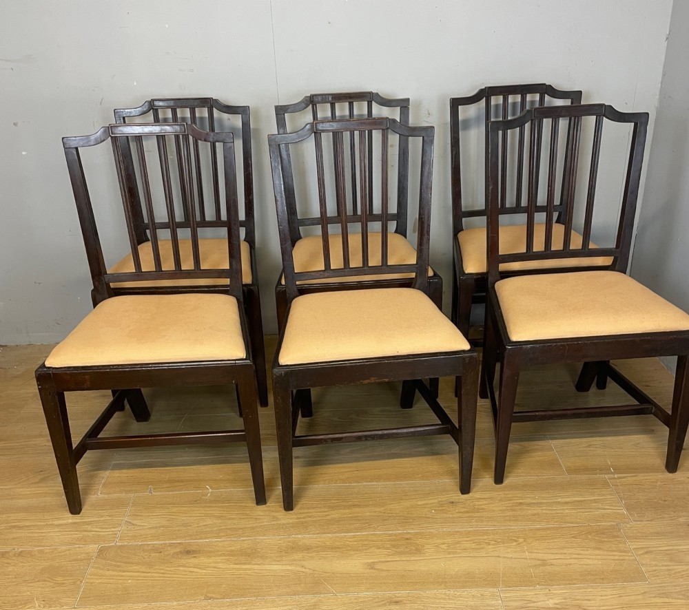 A set of six late Georgian dark mahogany country-made dining chairs featuring vertical bar backs and padded light tan upholstered drop-in seats. View III