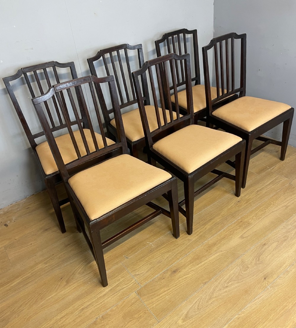A set of six late Georgian dark mahogany country-made dining chairs featuring vertical bar backs and padded light tan upholstered drop-in seats. View IV