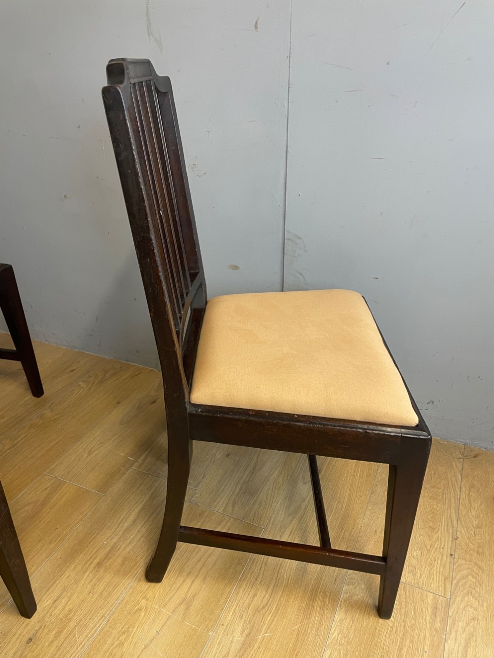 A set of six late Georgian dark mahogany country-made dining chairs featuring vertical bar backs and padded light tan upholstered drop-in seats. View VII