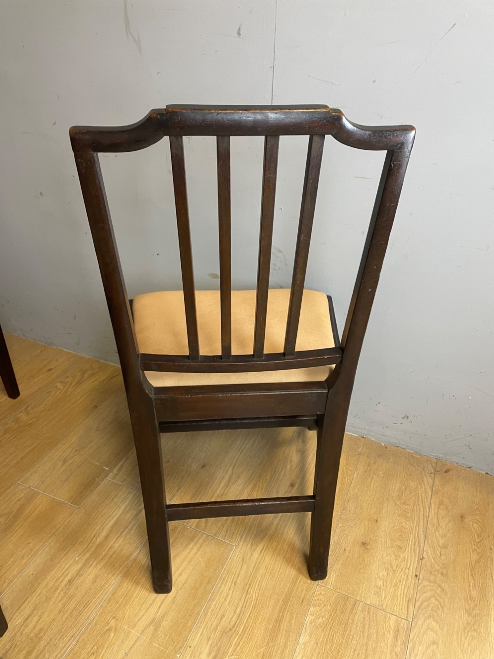 A set of six late Georgian dark mahogany country-made dining chairs featuring vertical bar backs and padded light tan upholstered drop-in seats. View VIII