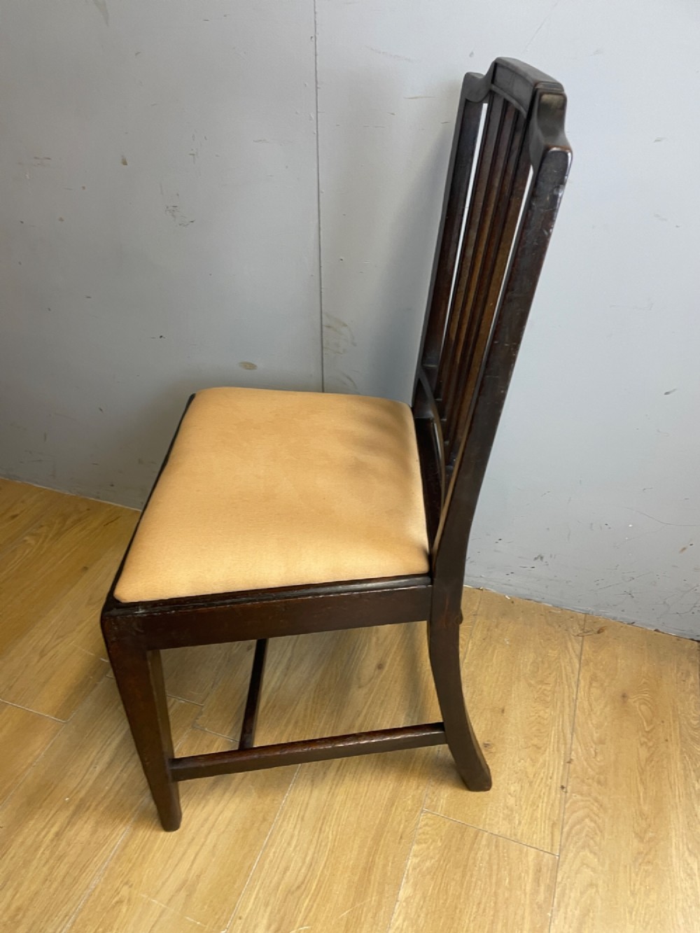 A set of six late Georgian dark mahogany country-made dining chairs featuring vertical bar backs and padded light tan upholstered drop-in seats. View IX
