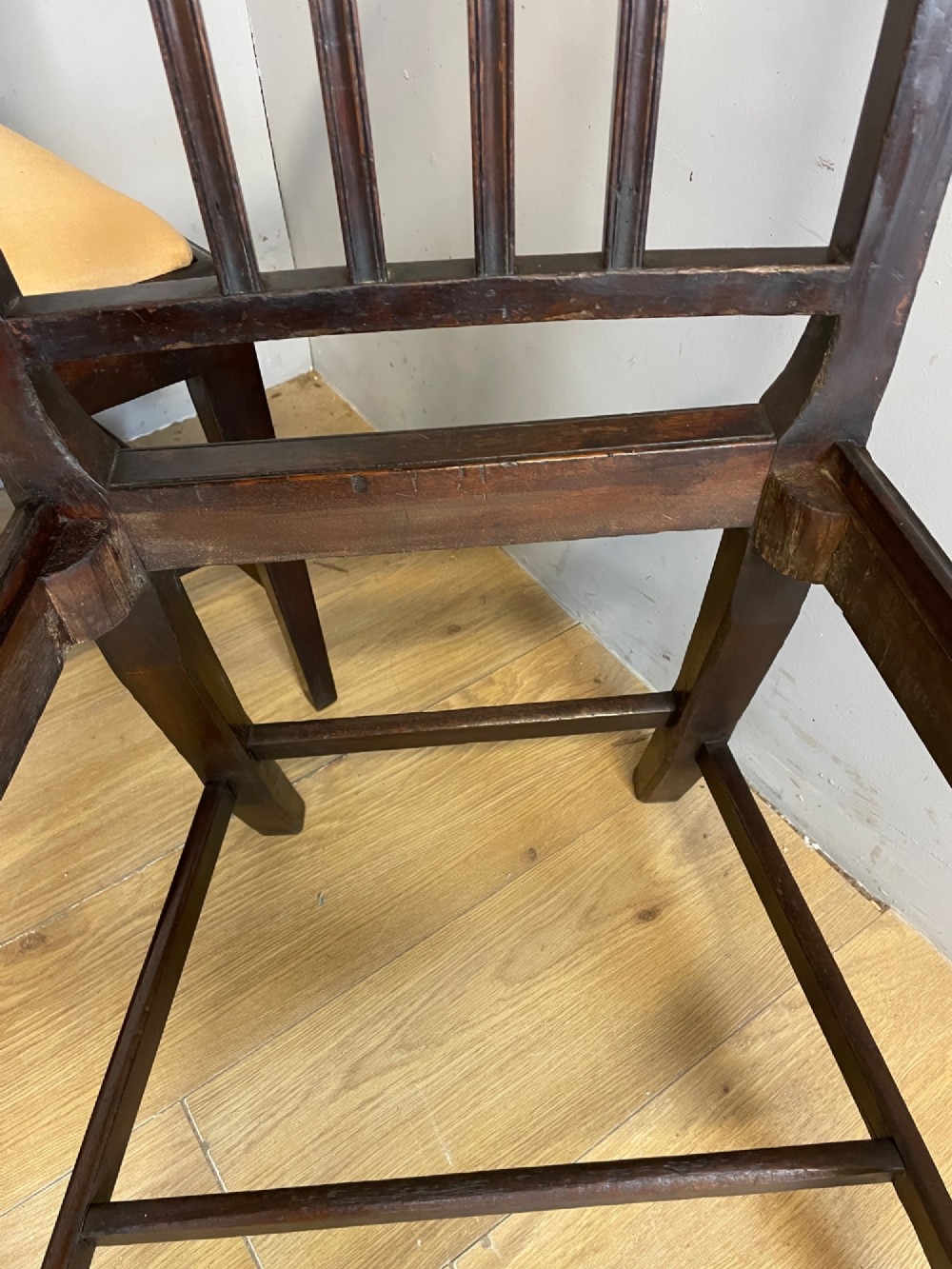 A set of six late Georgian dark mahogany country-made dining chairs featuring vertical bar backs and padded light tan upholstered drop-in seats. View XI
