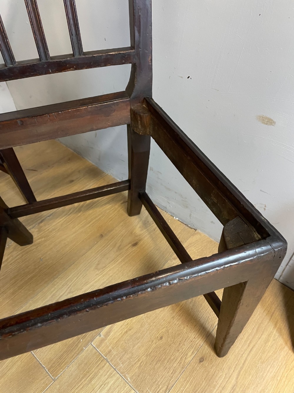 A set of six late Georgian dark mahogany country-made dining chairs featuring vertical bar backs and padded light tan upholstered drop-in seats. View XII