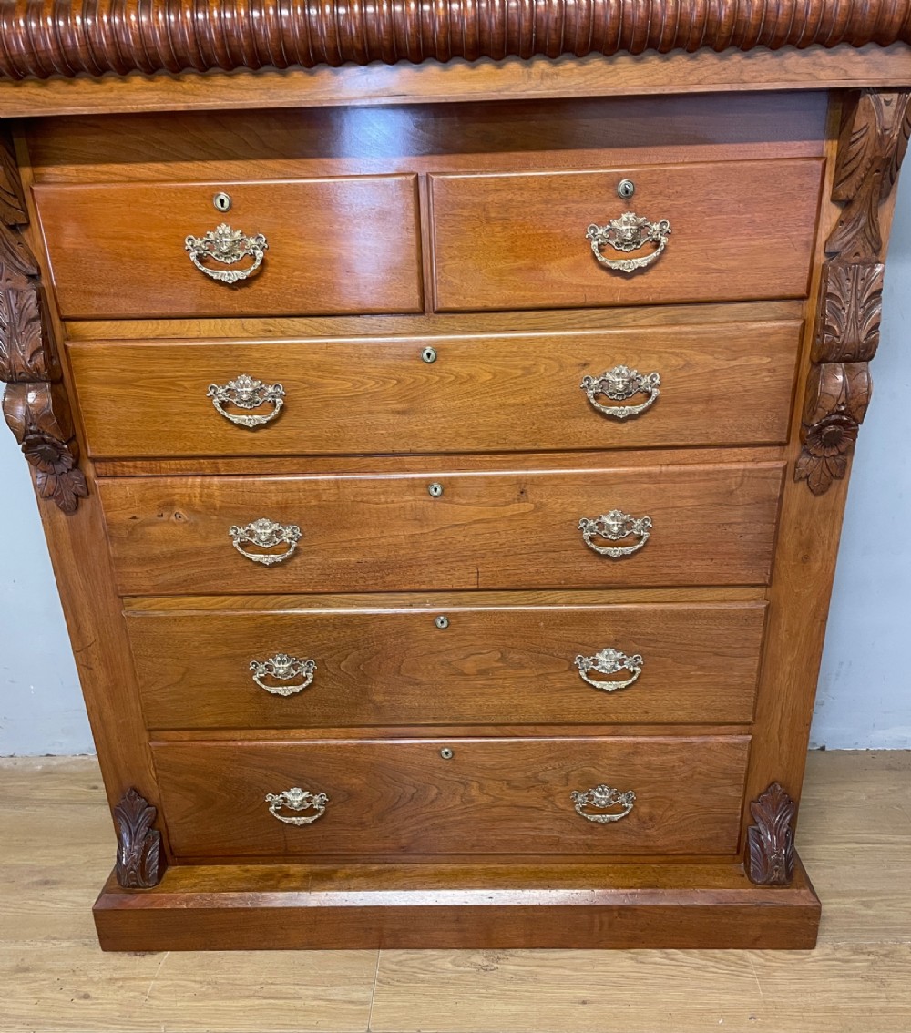 A 19th-century Scottish walnut chest of drawers featuring carved acanthus corbels, a gadrooned top frieze, and ornate brass drop handles. View III