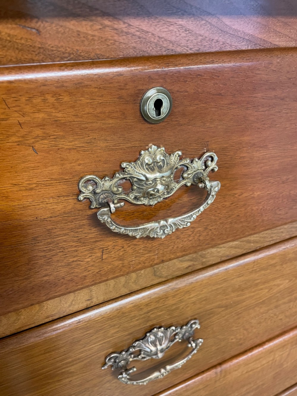 A 19th-century Scottish walnut chest of drawers featuring carved acanthus corbels, a gadrooned top frieze, and ornate brass drop handles. View VII