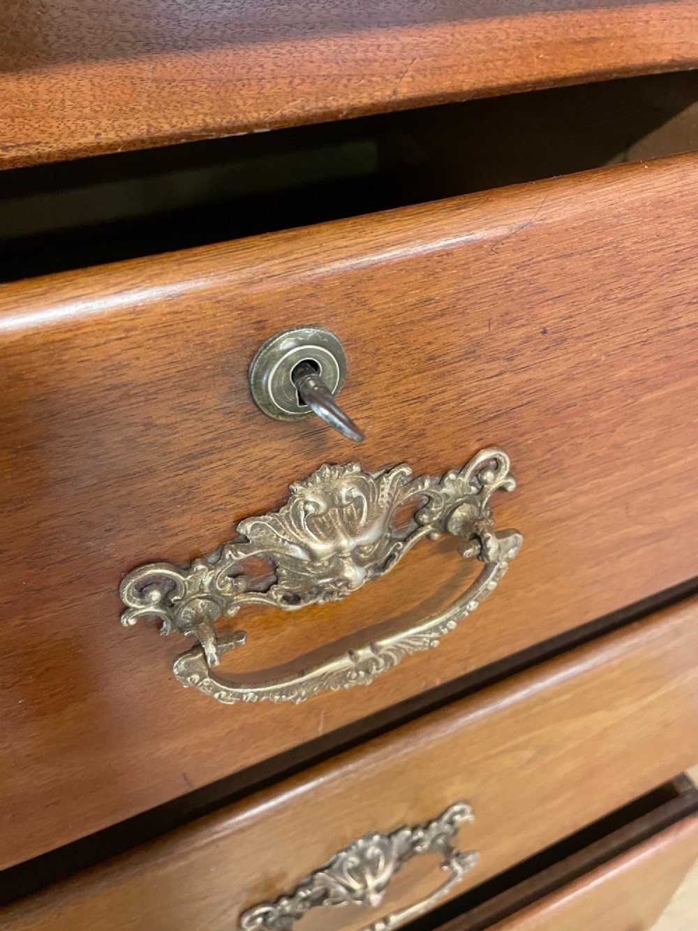 A 19th-century Scottish walnut chest of drawers featuring carved acanthus corbels, a gadrooned top frieze, and ornate brass drop handles. View IX