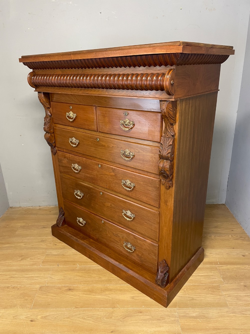 A 19th-century Scottish walnut chest of drawers featuring carved acanthus corbels, a gadrooned top frieze, and ornate brass drop handles. View XI