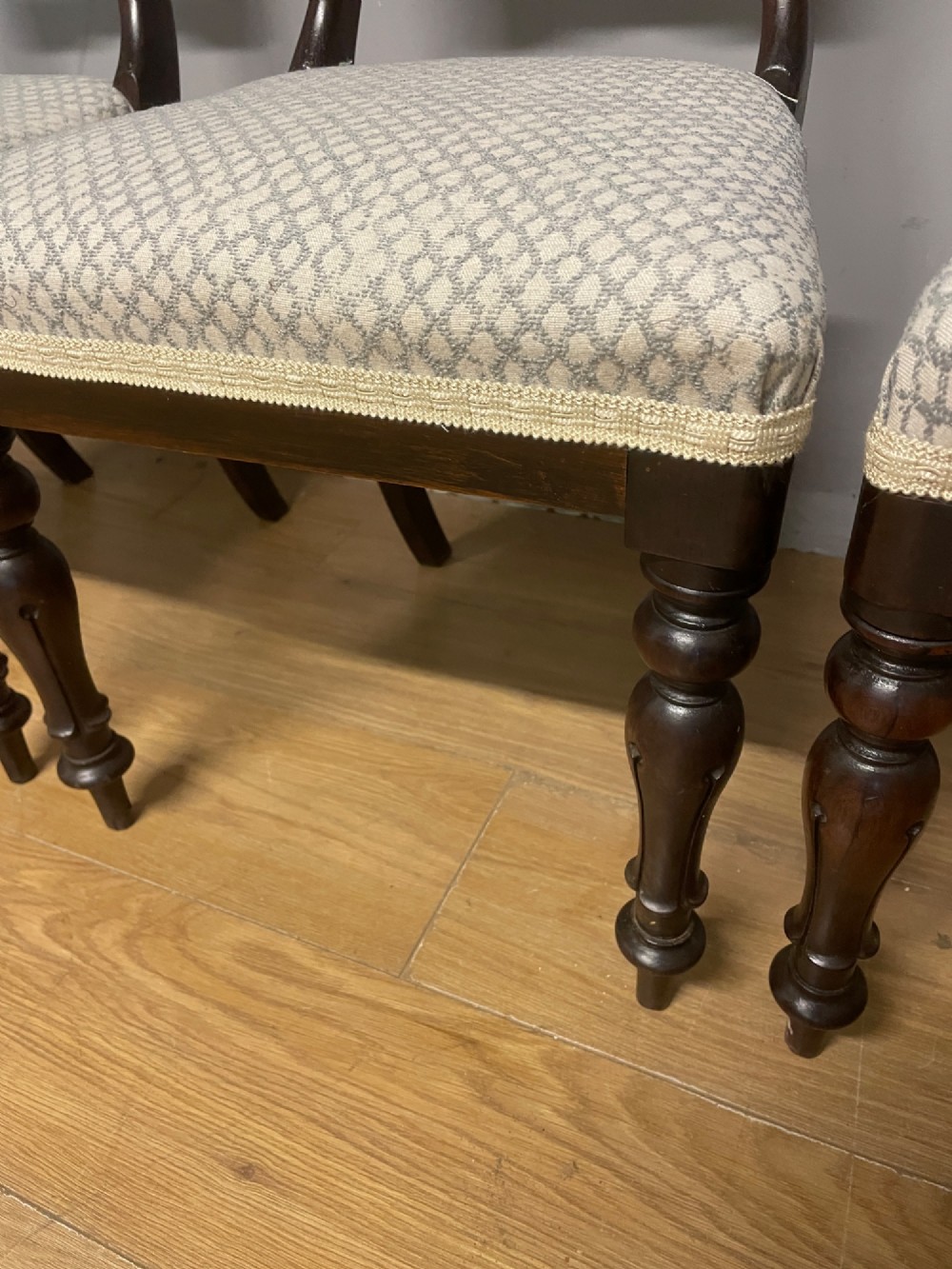 A set of four Victorian rosewood balloon back dining chairs with carved mid-rails, turned front legs, and grey patterned upholstered seats. View III