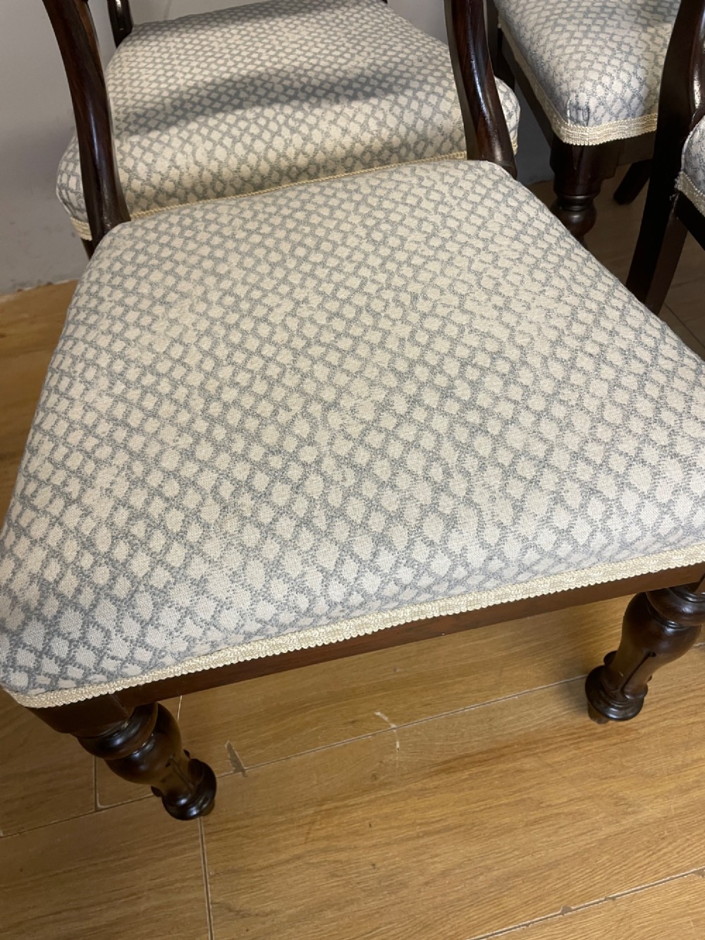 A set of four Victorian rosewood balloon back dining chairs with carved mid-rails, turned front legs, and grey patterned upholstered seats. View IX