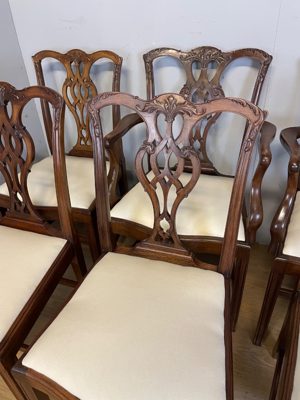 A set of eight solid mahogany Chippendale style dining chairs with intricate carved pierced splats and light cream drop-in seats. View III