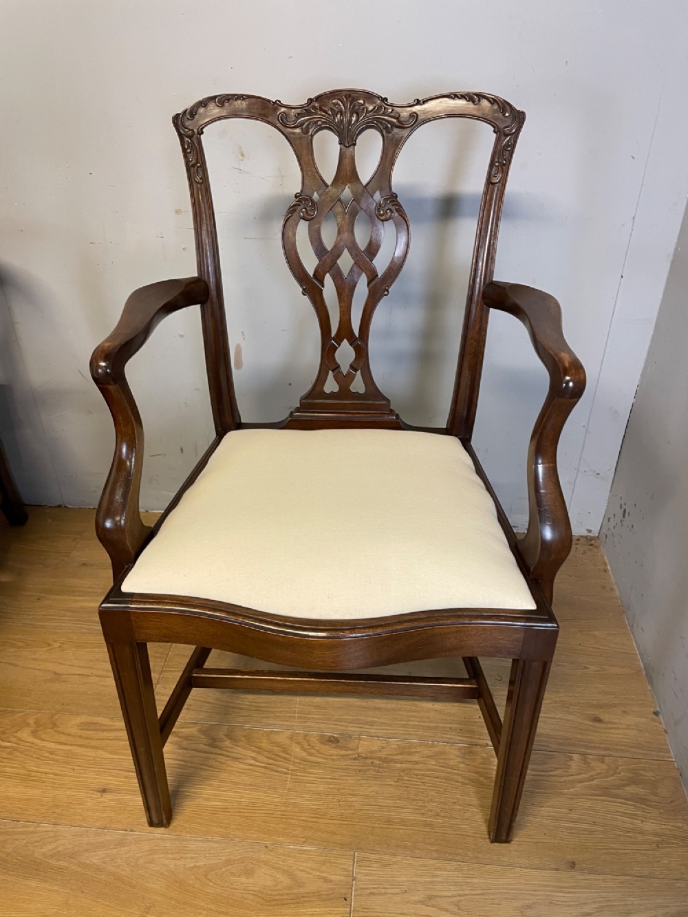 A set of eight solid mahogany Chippendale style dining chairs with intricate carved pierced splats and light cream drop-in seats. View VI