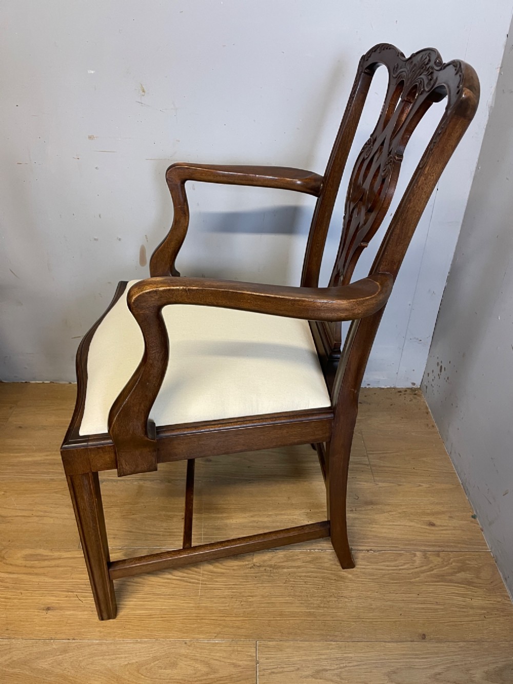 A set of eight solid mahogany Chippendale style dining chairs with intricate carved pierced splats and light cream drop-in seats. View VII