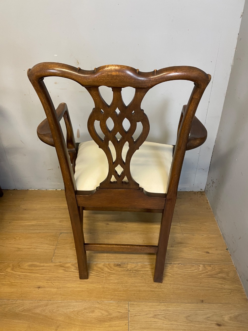 A set of eight solid mahogany Chippendale style dining chairs with intricate carved pierced splats and light cream drop-in seats. View VIII