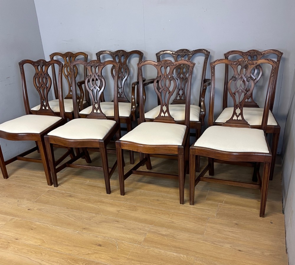 A set of eight solid mahogany Chippendale style dining chairs with intricate carved pierced splats and light cream drop-in seats. View XIV