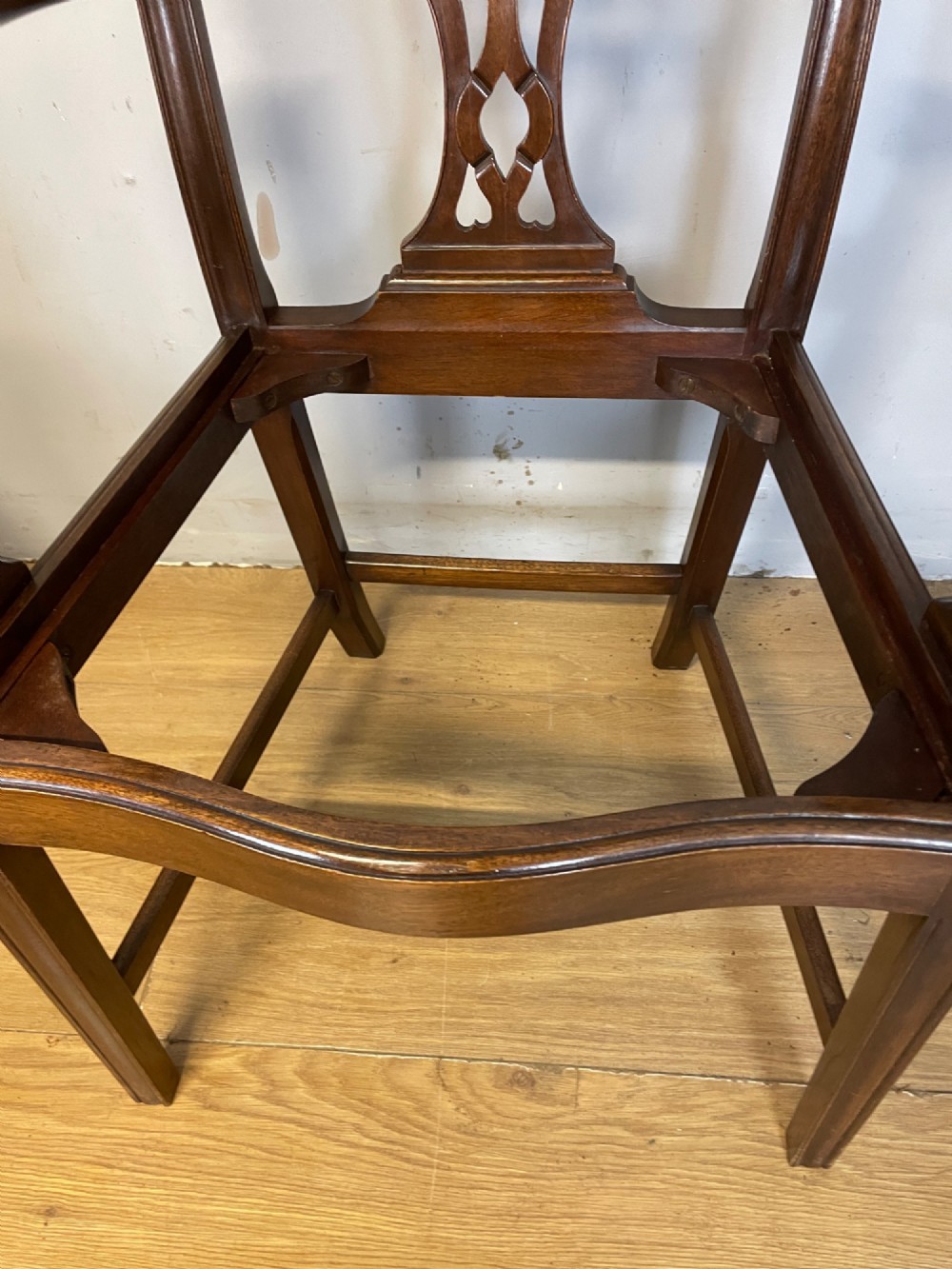 A set of eight solid mahogany Chippendale style dining chairs with intricate carved pierced splats and light cream drop-in seats. View XV