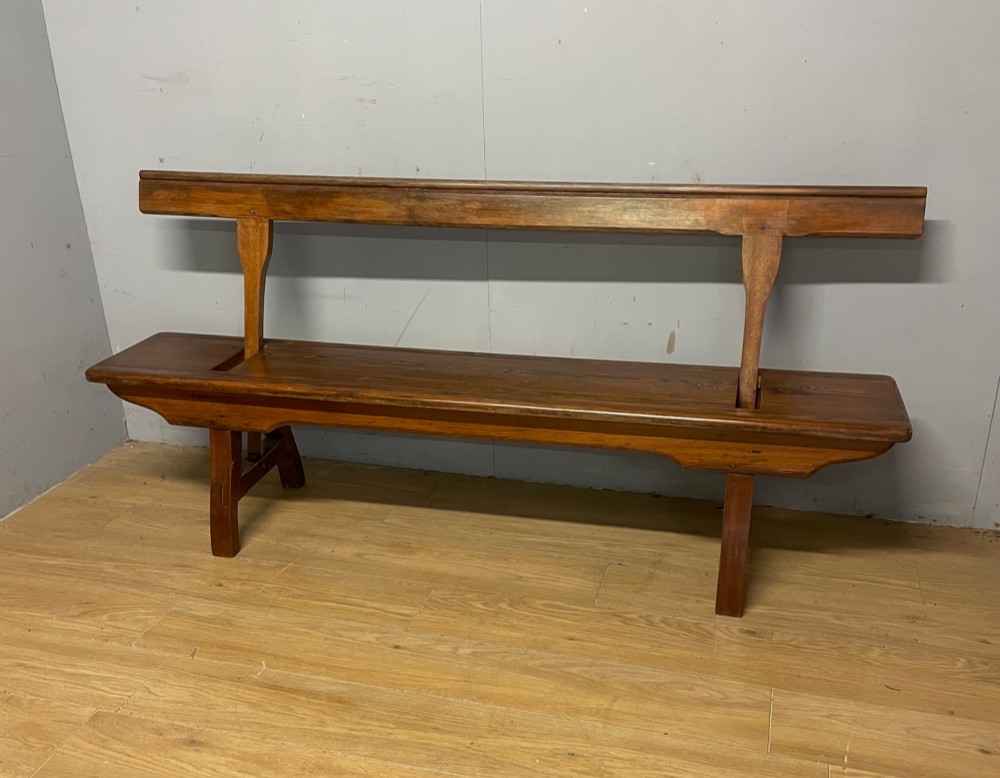 A Victorian pitch pine and mahogany bench featuring a long solid seat and a reversible swing backrest. View II