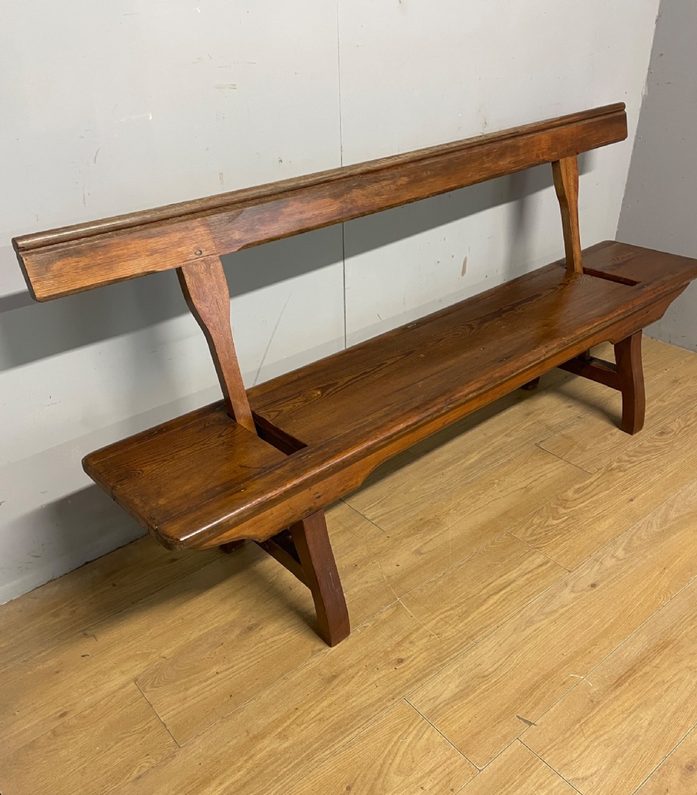 A Victorian pitch pine and mahogany bench featuring a long solid seat and a reversible swing backrest. View III