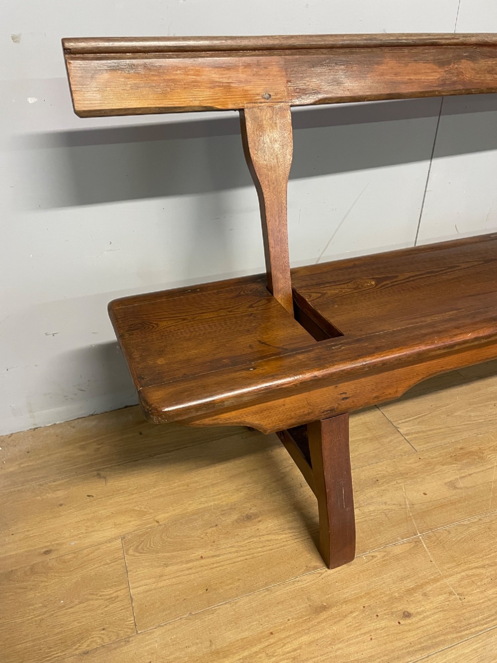 A Victorian pitch pine and mahogany bench featuring a long solid seat and a reversible swing backrest. View IV