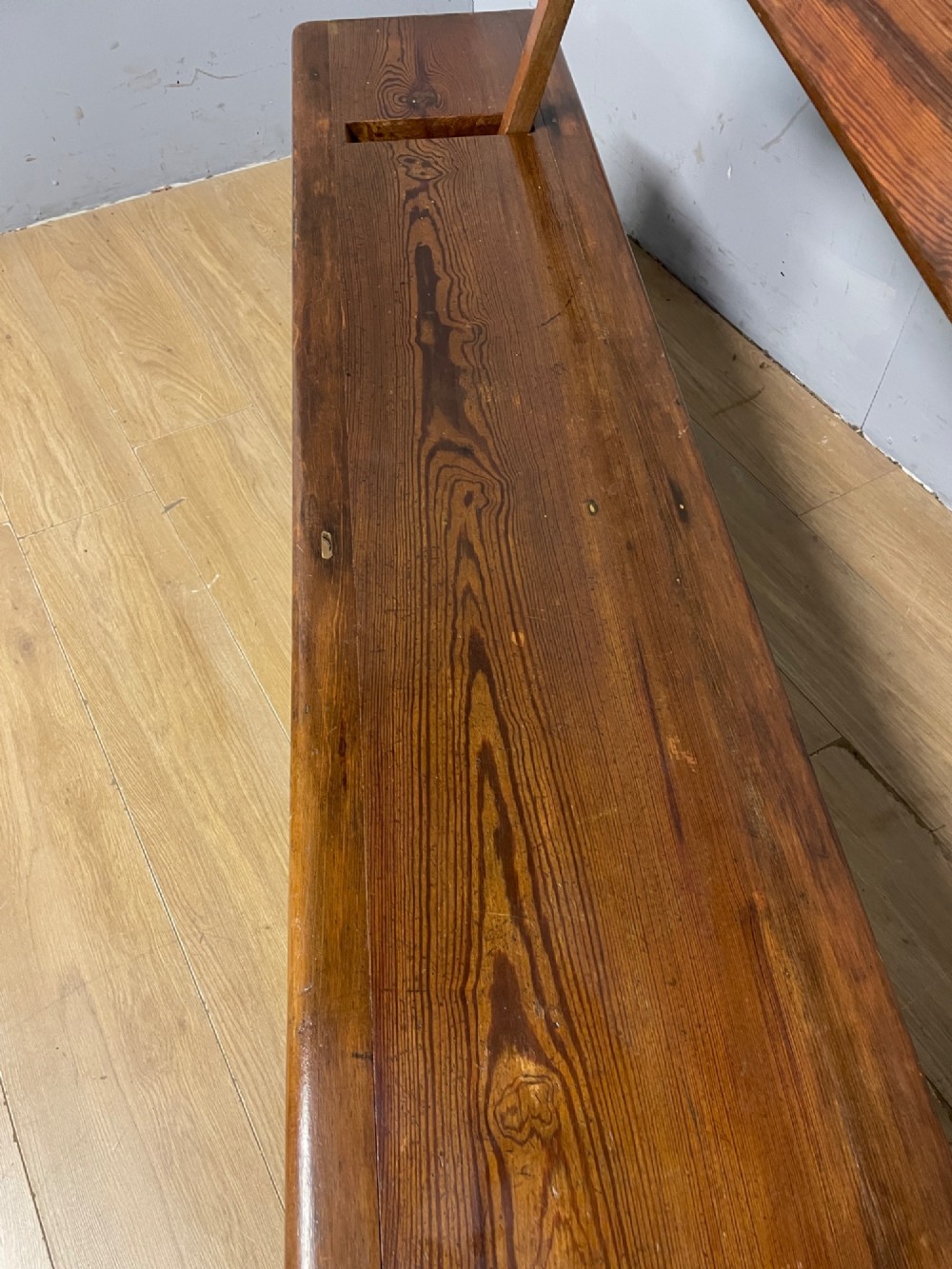 A Victorian pitch pine and mahogany bench featuring a long solid seat and a reversible swing backrest. View VII