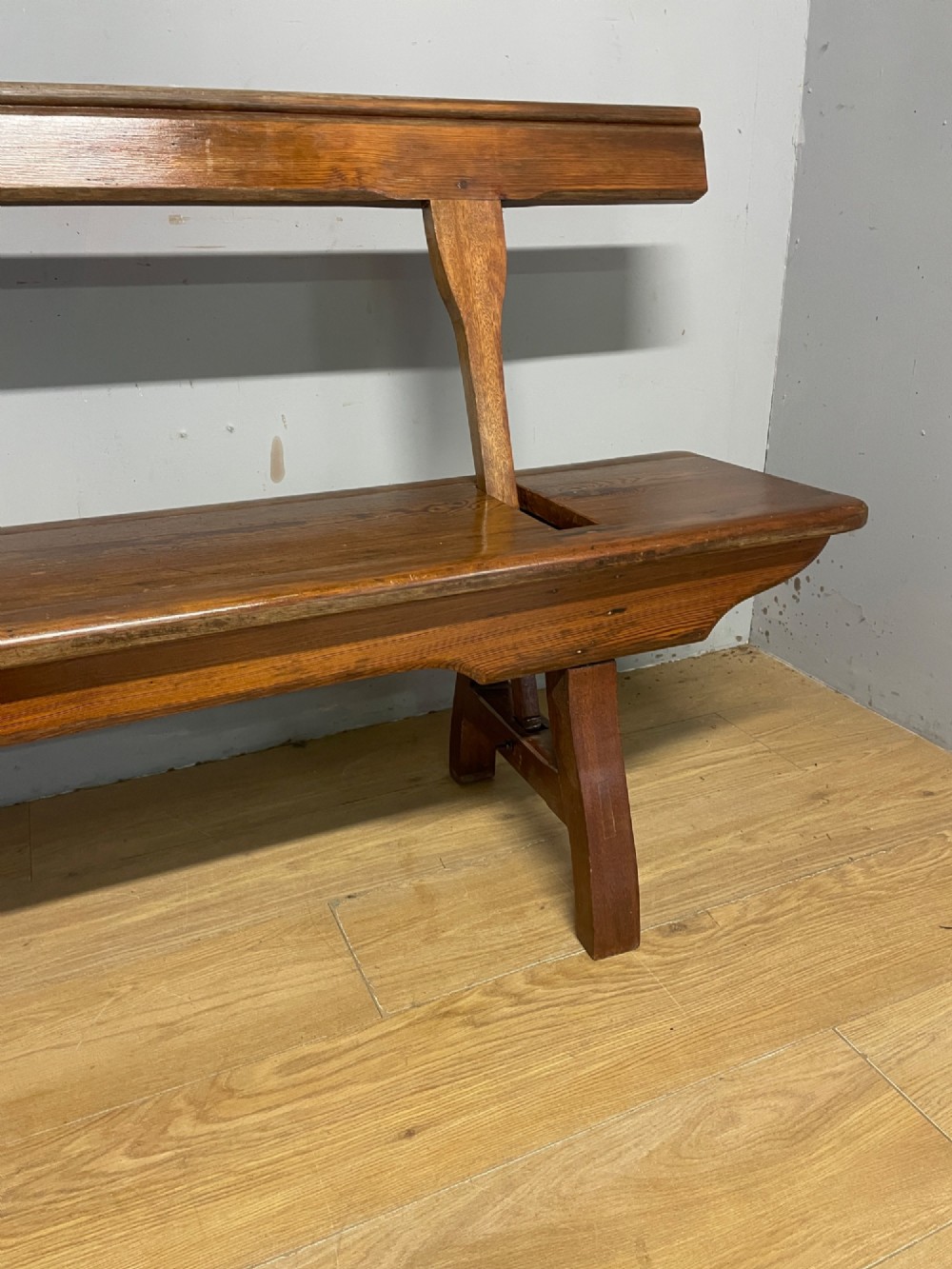 A Victorian pitch pine and mahogany bench featuring a long solid seat and a reversible swing backrest. View IX