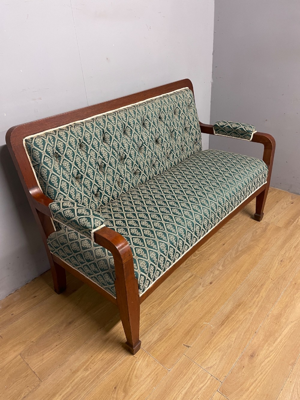 Late nineteenth-century mahogany frame two-seater sofa with deep buttoned green and cream patterned fabric upholstery. View IV