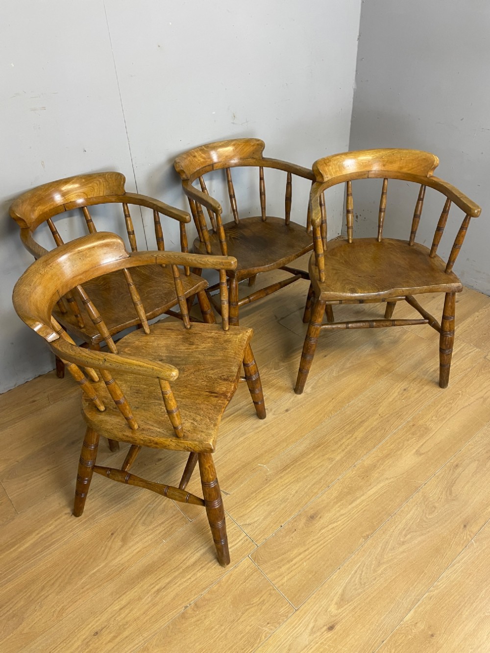 Set of four 19th-century bow back Windsor armchairs constructed from warm brown elm with turned spindle backs and legs. View II