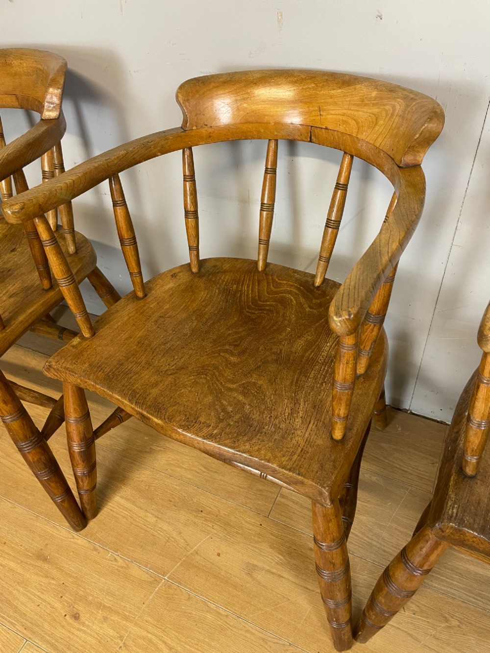 Set of four 19th-century bow back Windsor armchairs constructed from warm brown elm with turned spindle backs and legs. View IV