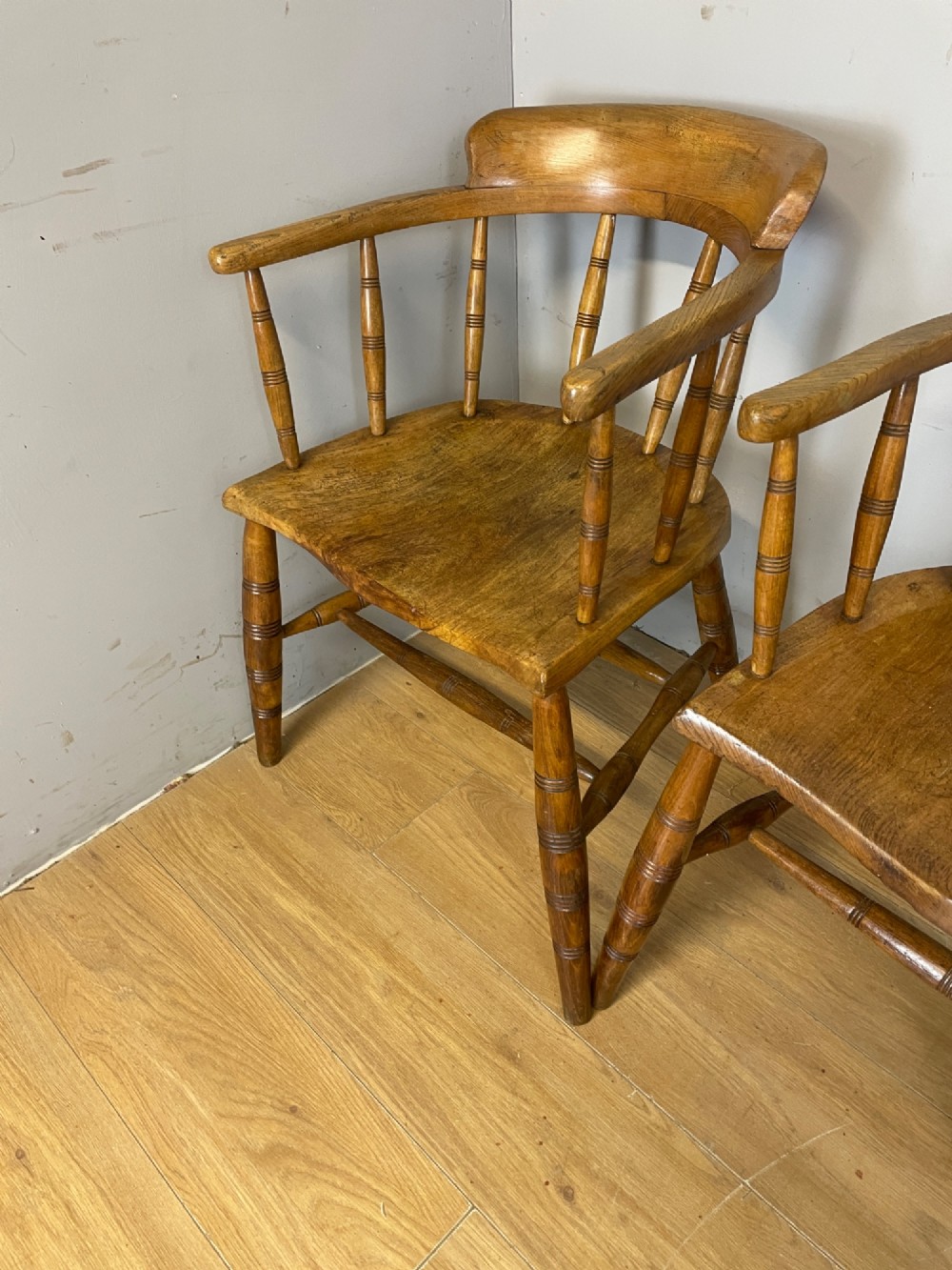 Set of four 19th-century bow back Windsor armchairs constructed from warm brown elm with turned spindle backs and legs. View V