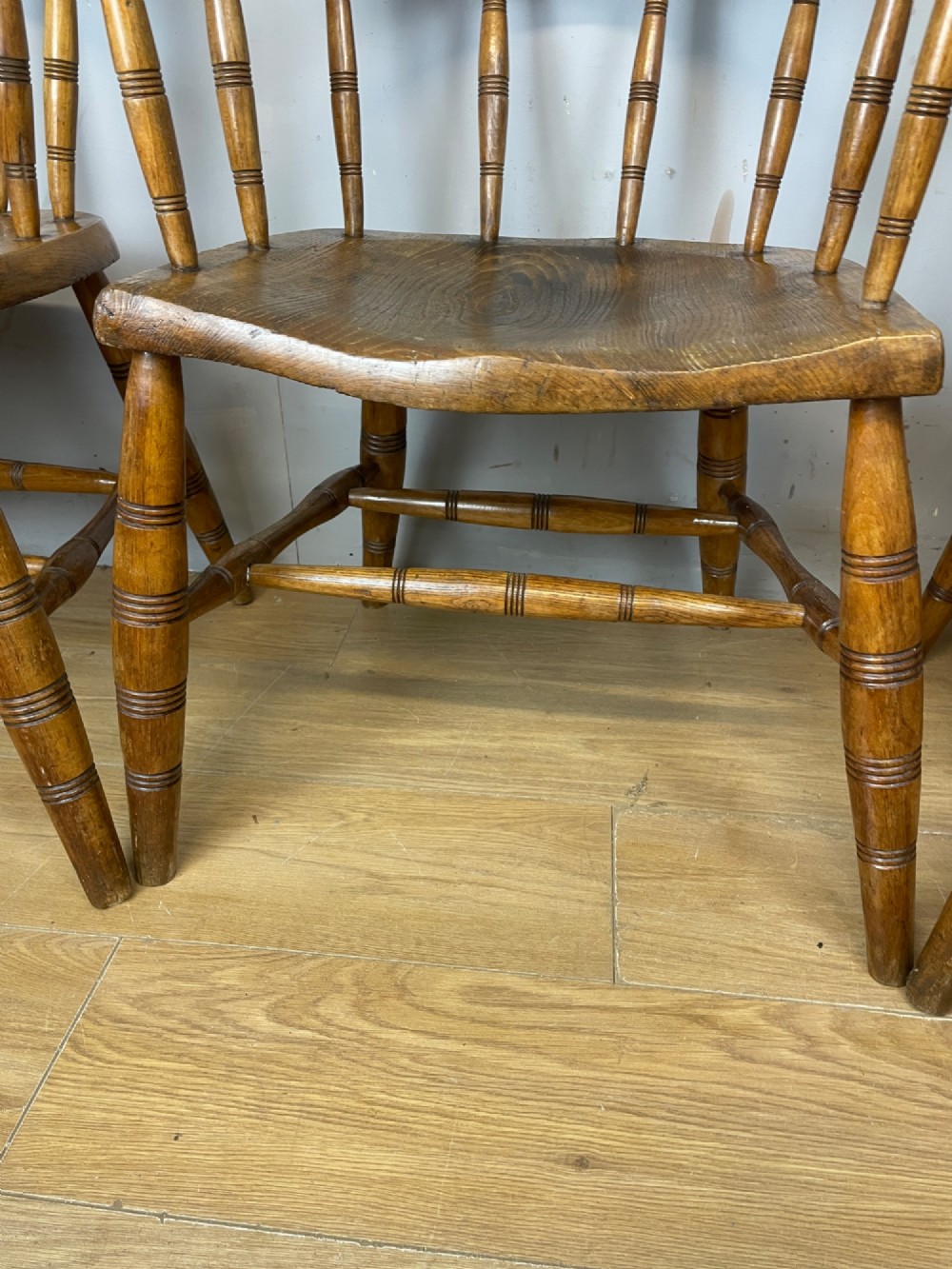 Set of four 19th-century bow back Windsor armchairs constructed from warm brown elm with turned spindle backs and legs. View VII