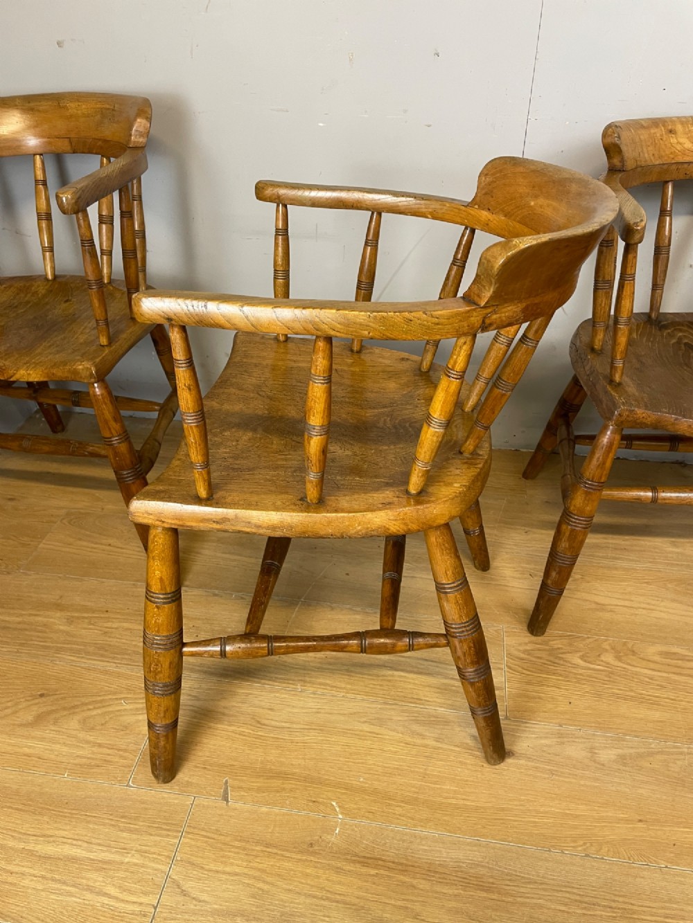 Set of four 19th-century bow back Windsor armchairs constructed from warm brown elm with turned spindle backs and legs. View VIII