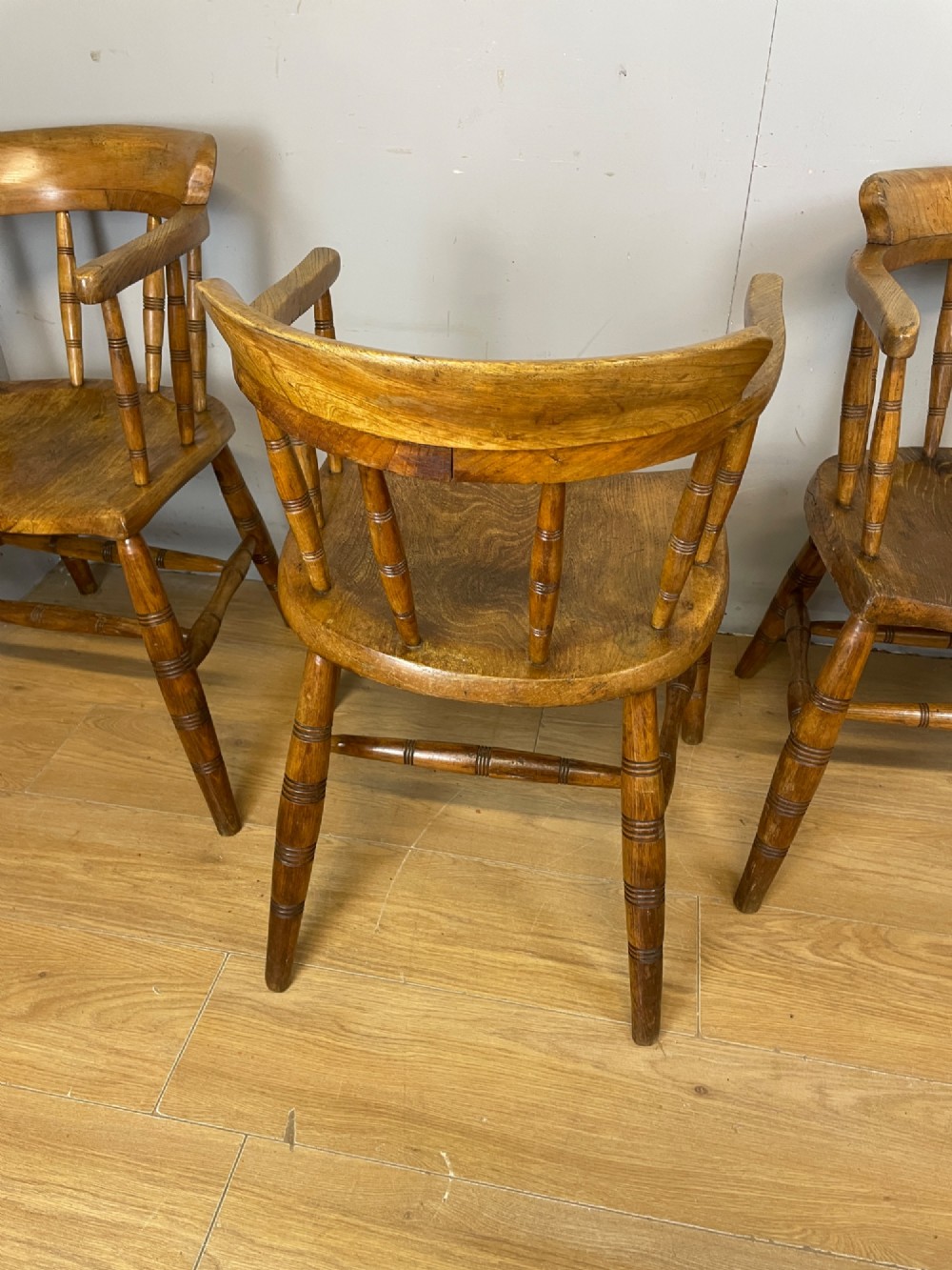 Set of four 19th-century bow back Windsor armchairs constructed from warm brown elm with turned spindle backs and legs. View IX