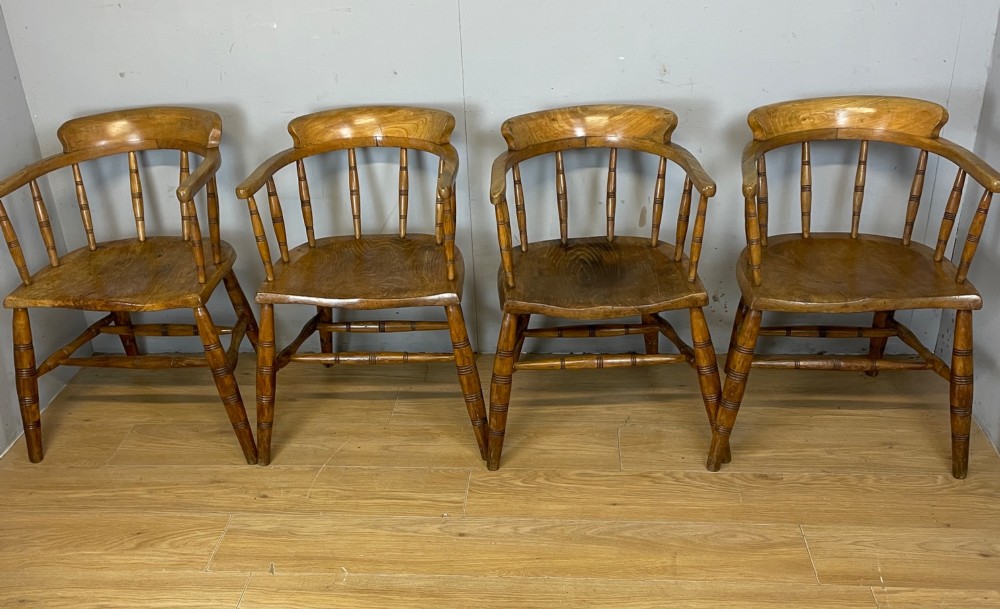 Set of four 19th-century bow back Windsor armchairs constructed from warm brown elm with turned spindle backs and legs. View X