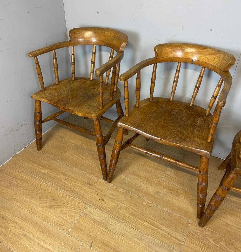 Set of four 19th-century bow back Windsor armchairs constructed from warm brown elm with turned spindle backs and legs. View XI