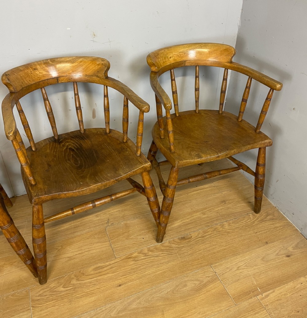 Set of four 19th-century bow back Windsor armchairs constructed from warm brown elm with turned spindle backs and legs. View XII