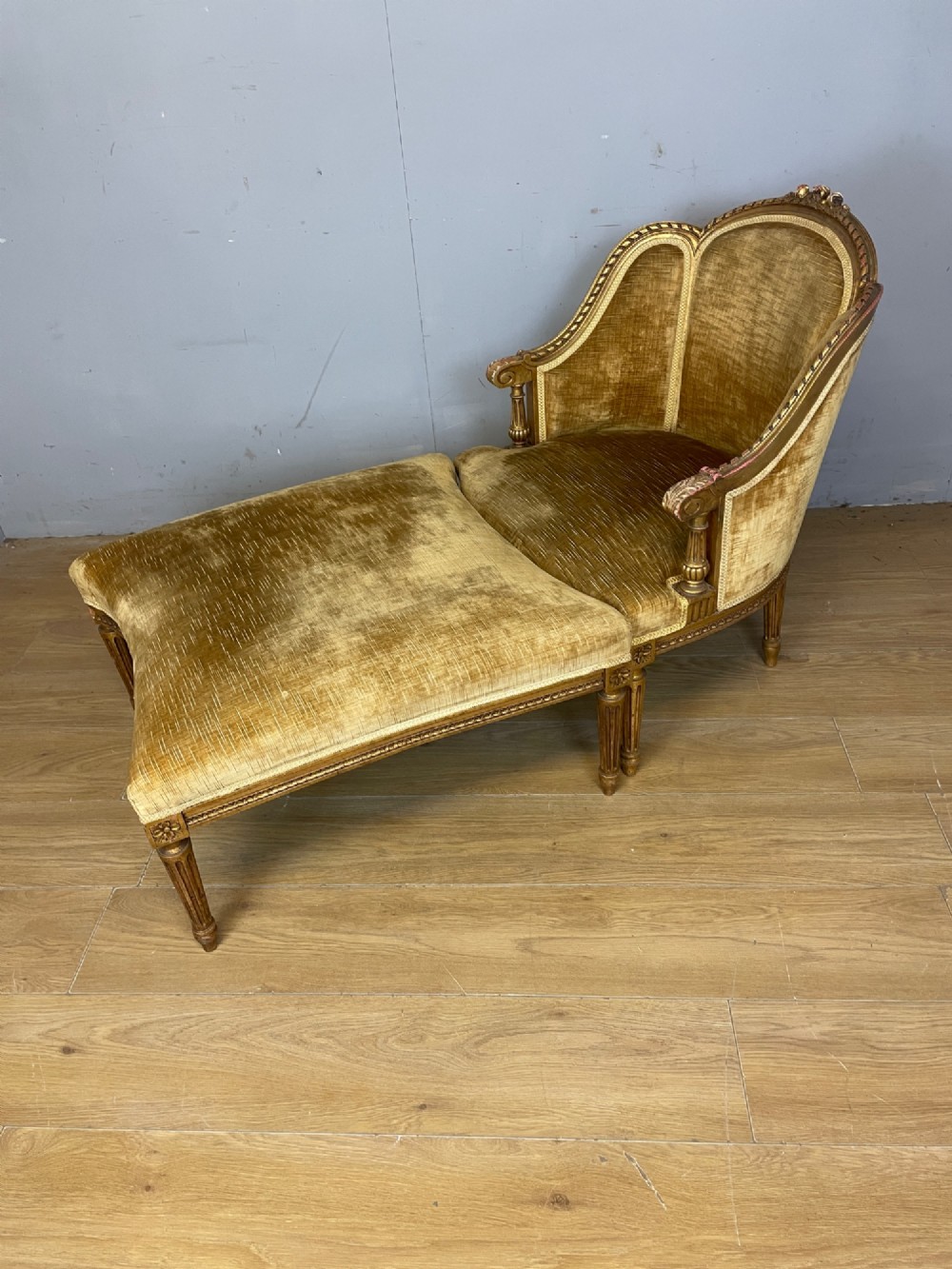 An Edwardian carved giltwood armchair with a matching rectangular footstool upholstered in gold velvet. View II
