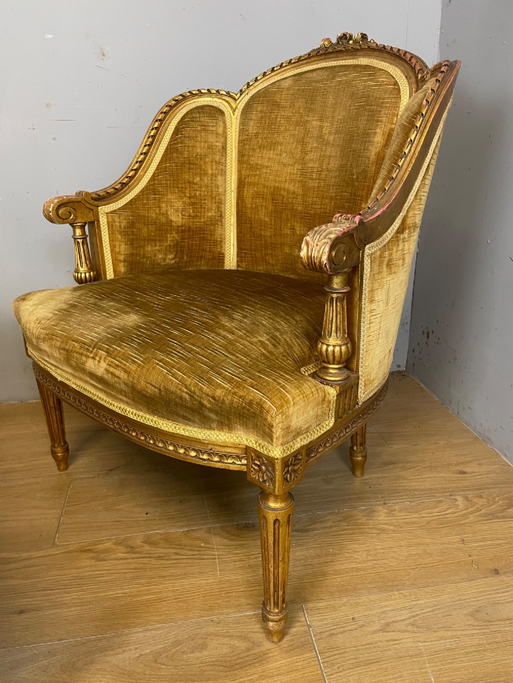 An Edwardian carved giltwood armchair with a matching rectangular footstool upholstered in gold velvet. View IV