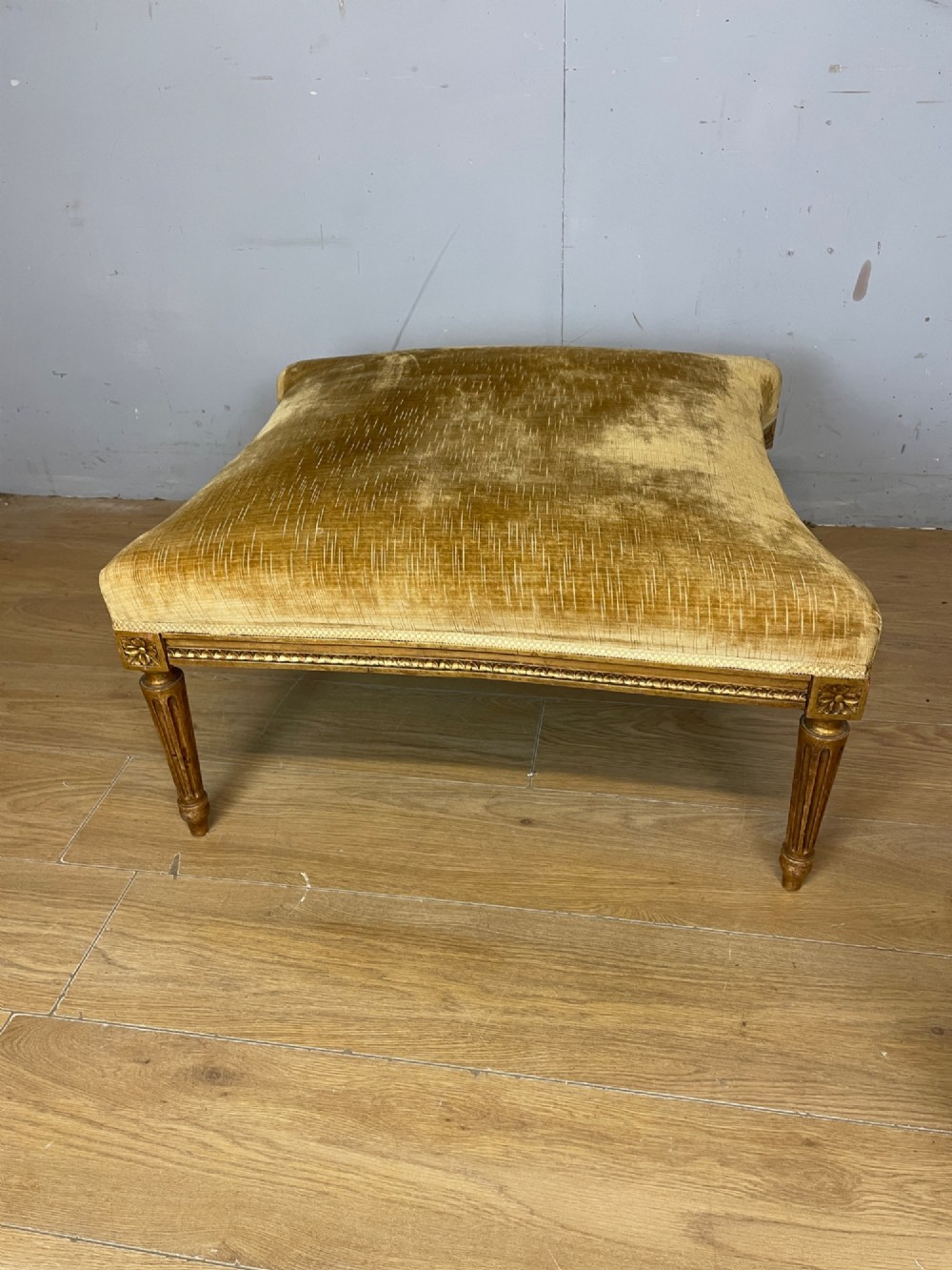 An Edwardian carved giltwood armchair with a matching rectangular footstool upholstered in gold velvet. View VII