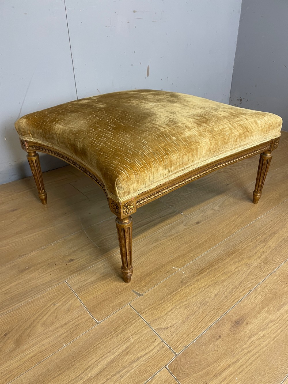 An Edwardian carved giltwood armchair with a matching rectangular footstool upholstered in gold velvet. View VIII