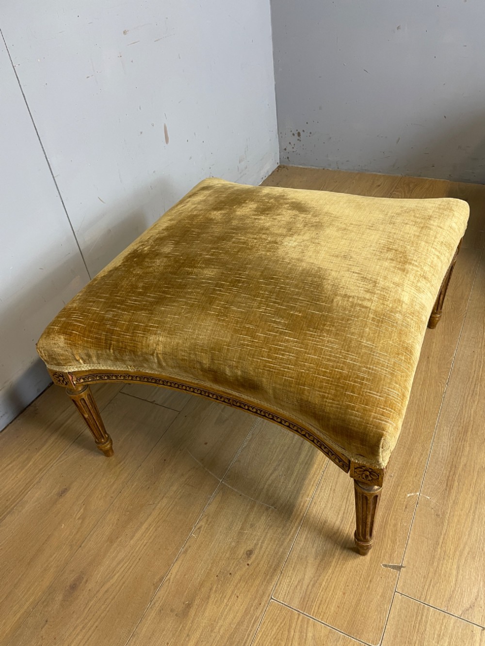 An Edwardian carved giltwood armchair with a matching rectangular footstool upholstered in gold velvet. View IX
