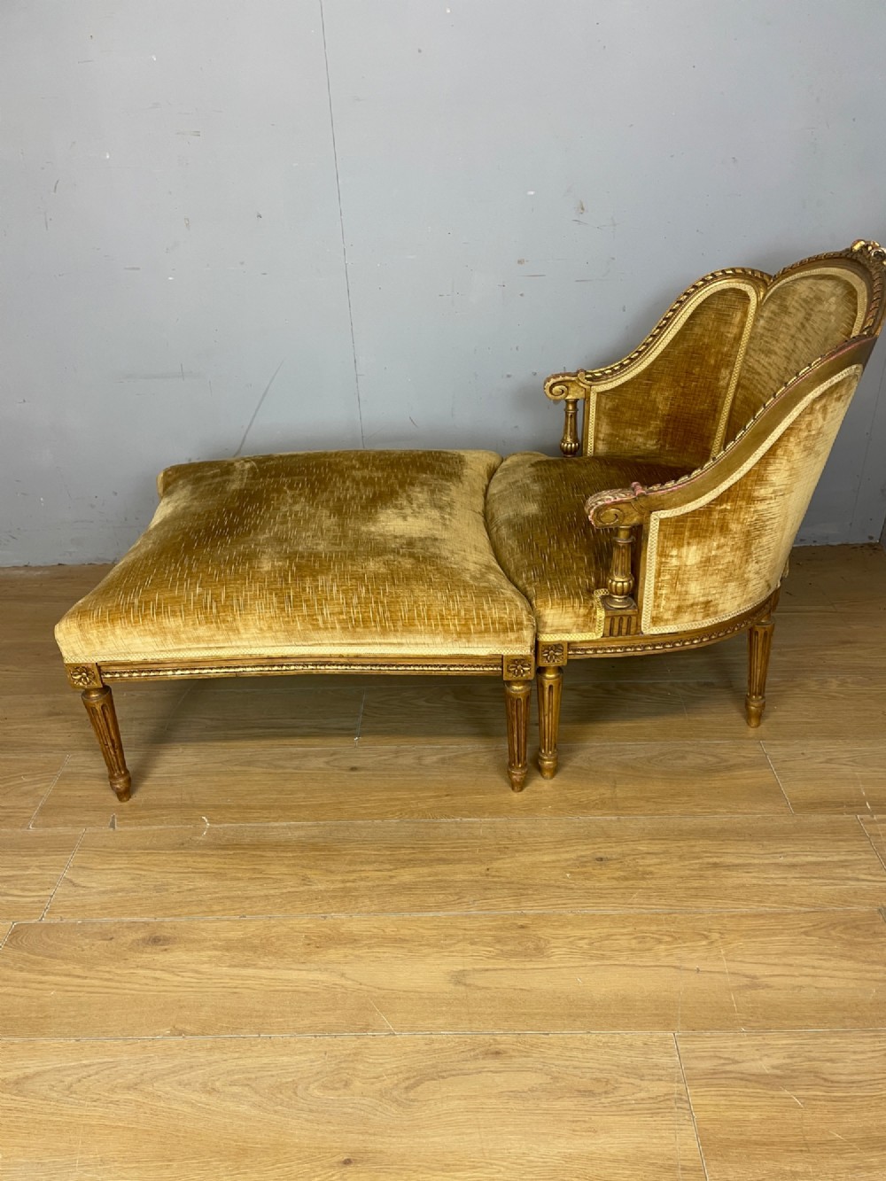 An Edwardian carved giltwood armchair with a matching rectangular footstool upholstered in gold velvet. View X