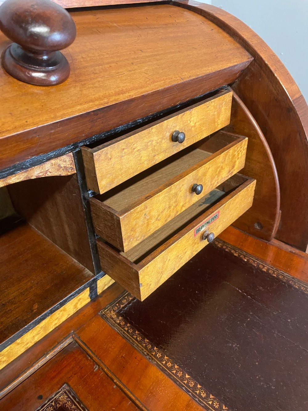 A nineteenth-century mahogany cylinder pedestal desk featuring a curved roll-down front, an extendable leather-lined writing slope, small interior drawers, and twin pedestals. View VI