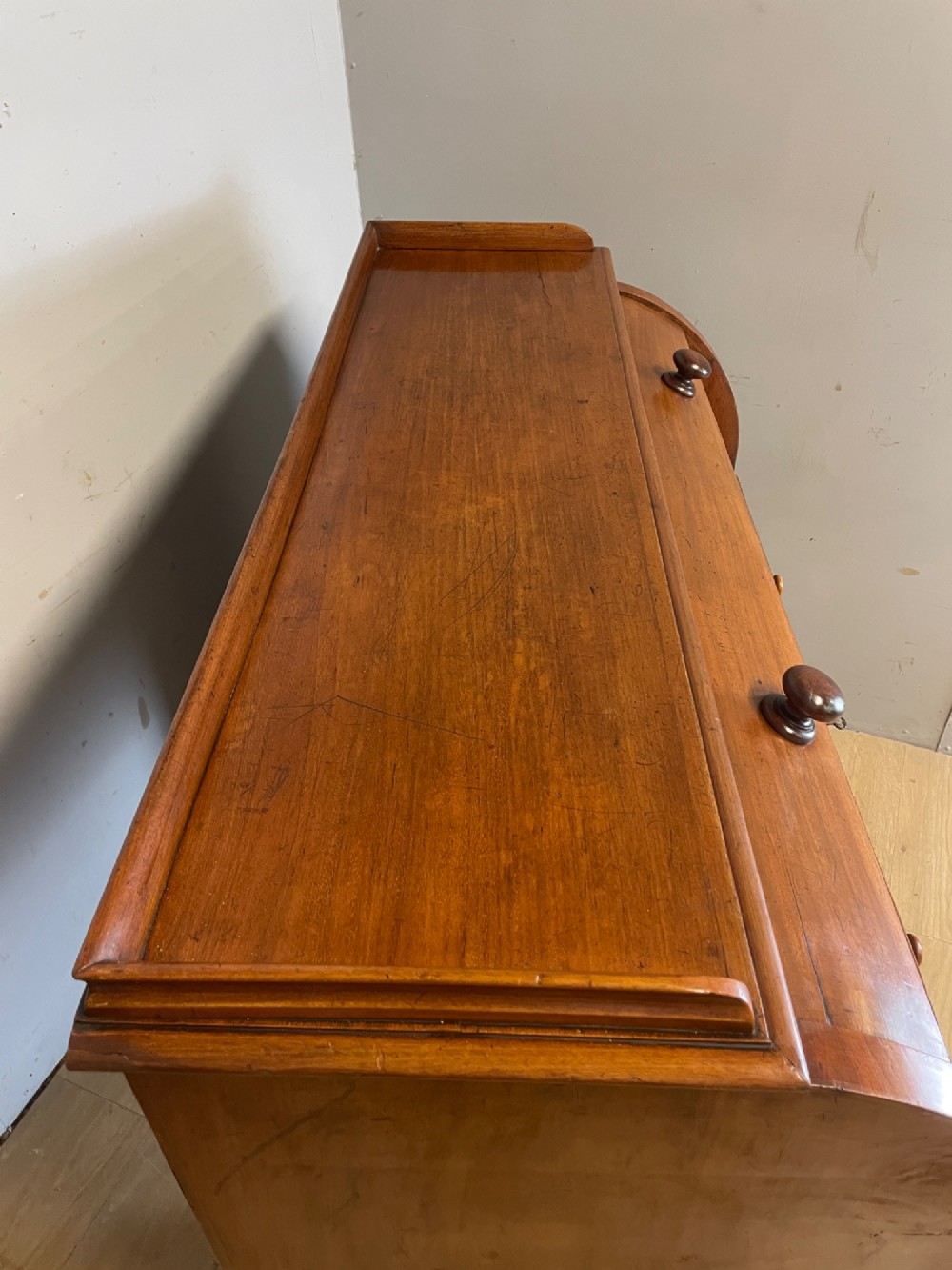 A nineteenth-century mahogany cylinder pedestal desk featuring a curved roll-down front, an extendable leather-lined writing slope, small interior drawers, and twin pedestals. View X