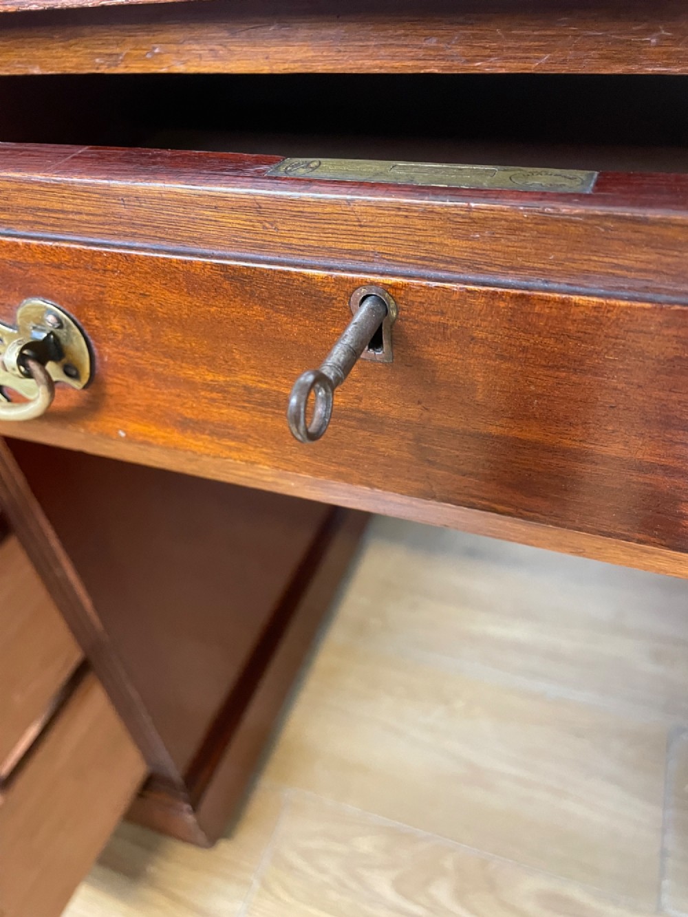 A nineteenth-century mahogany twin pedestal desk featuring nine drawers with brass swan-neck handles and a rectangular veneered top surface. View VI
