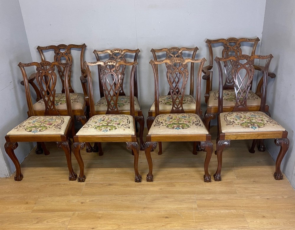 A set of eight dark mahogany Chippendale Revival dining chairs featuring carved pierced back splats, tapestry seat pads, and cabriole legs with ball and claw feet. View II