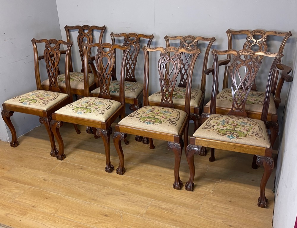 A set of eight dark mahogany Chippendale Revival dining chairs featuring carved pierced back splats, tapestry seat pads, and cabriole legs with ball and claw feet. View III