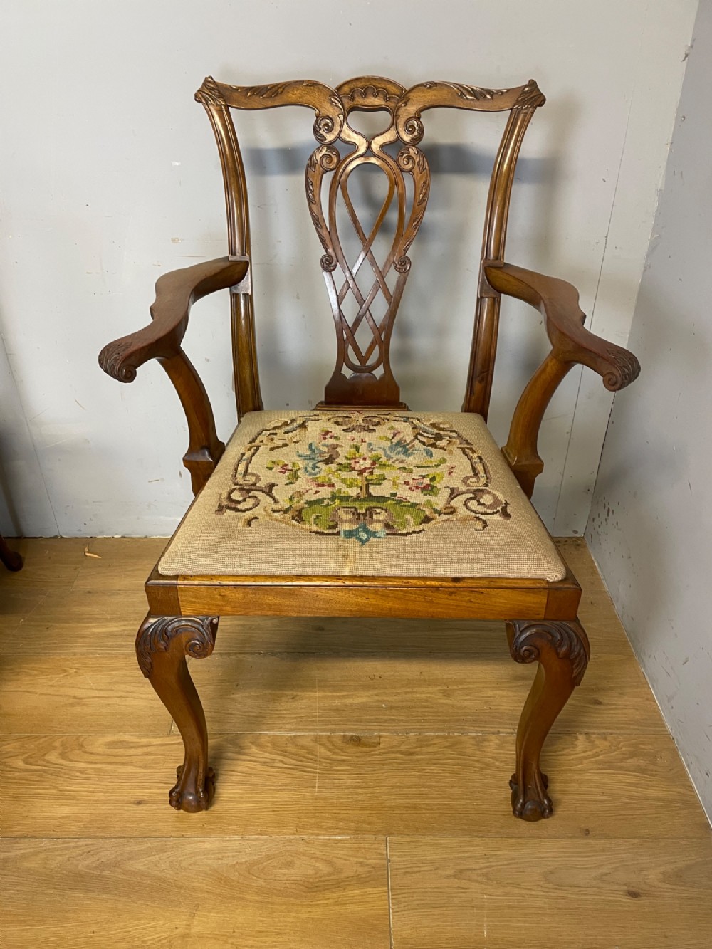 A set of eight dark mahogany Chippendale Revival dining chairs featuring carved pierced back splats, tapestry seat pads, and cabriole legs with ball and claw feet. View IV